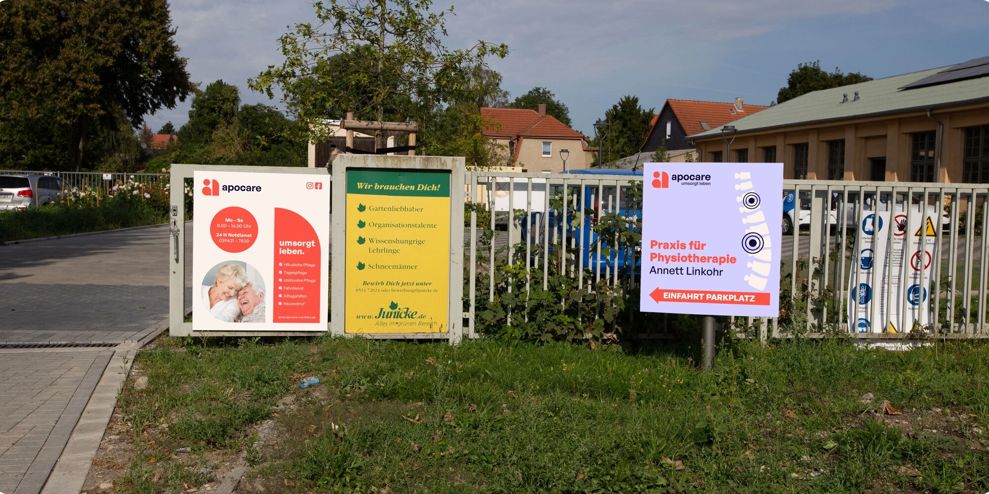 Drei Schilder stehen nebeneinander: links ein Apothekenschild mit \