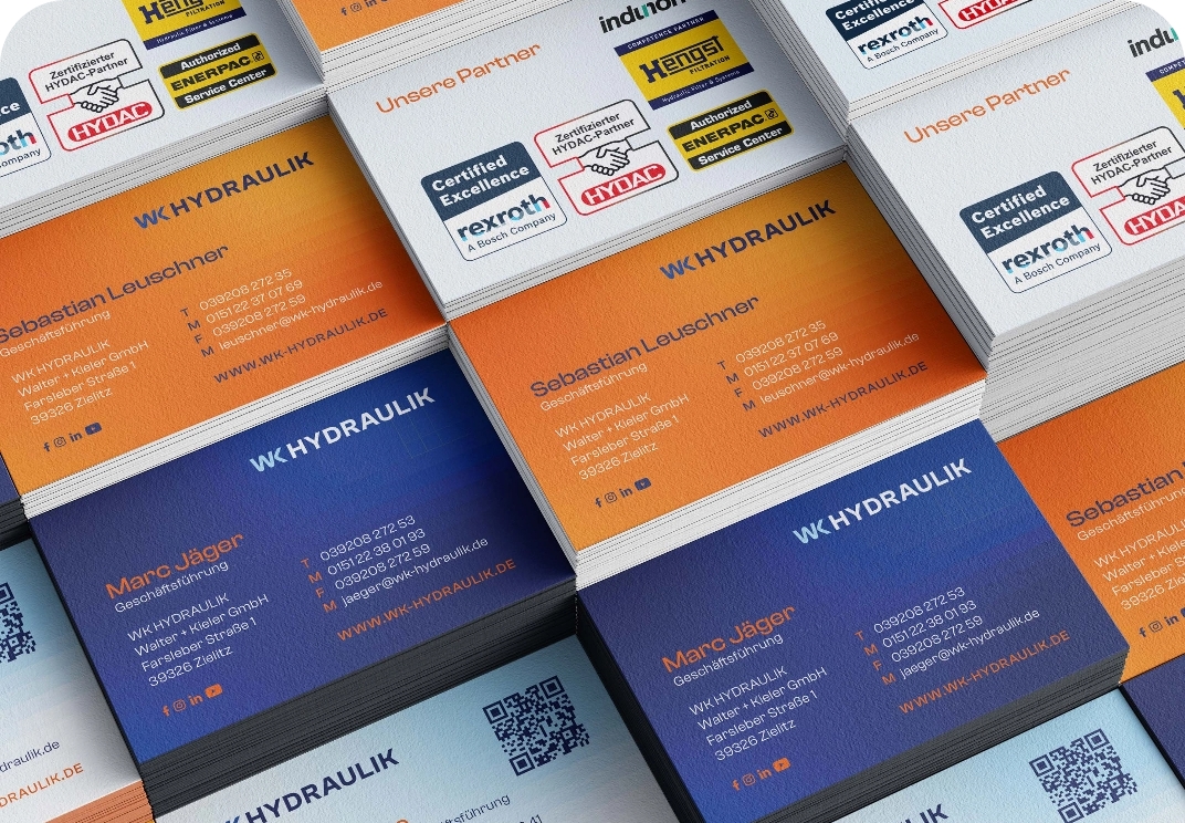 Stapel von Visitenkarten der Firma WK HYDRAULIK mit Kontaktdaten der Geschäftsführer Sebastian Leuschner und