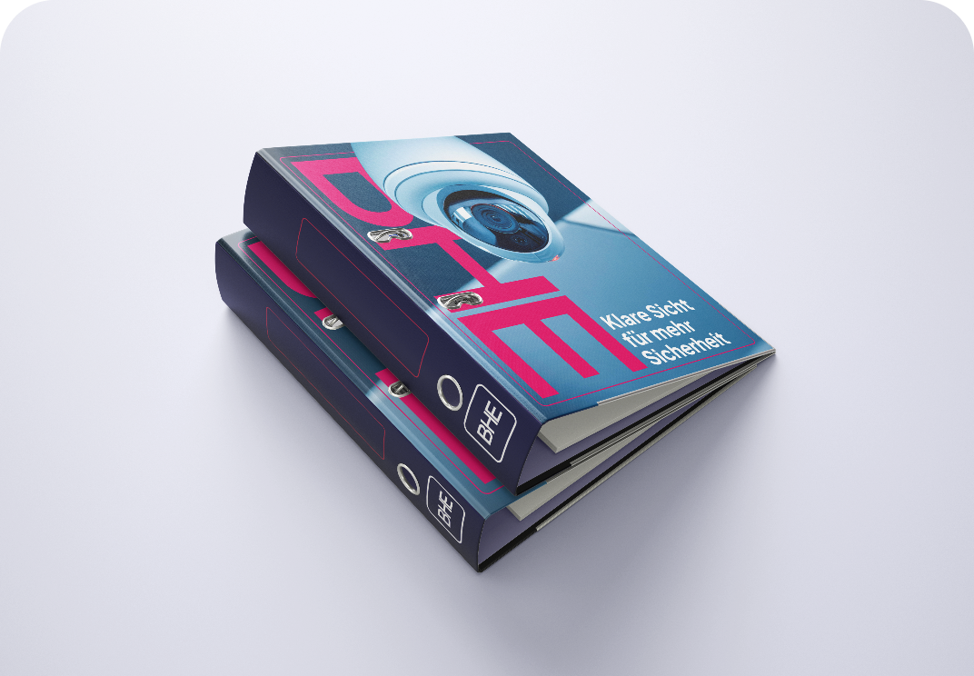 Zwei dunkelblaue Ordner liegen übereinander, der obere zeigt eine Überwachungskamera und den Text 'Klare Sicht